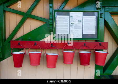 Red fire buckets on Alton Railway station, Alton, Hampshire, England, UK. Stock Photo