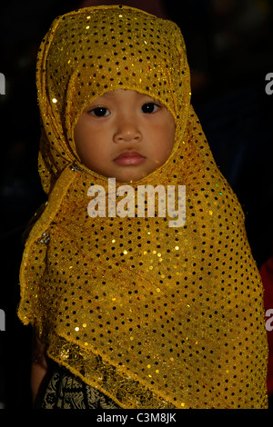 little muslim girl in traditional dress , street festival, bangkok, thailand Stock Photo