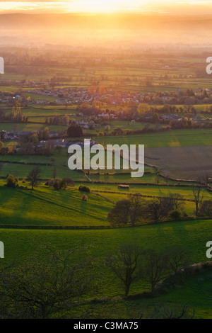 The sun setting over the Severn Vale village of Coaley, Gloucestershire, England, UK Stock Photo