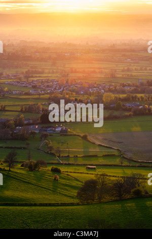 The sun setting over the Severn Vale village of Coaley, Gloucestershire, England, UK Stock Photo