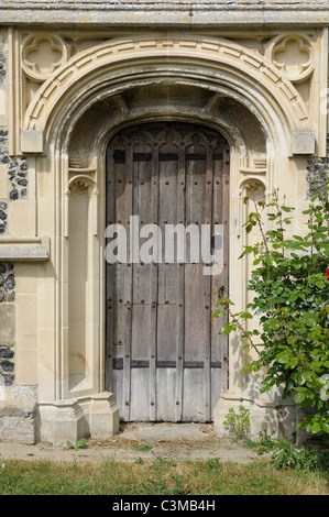 An old wooden door in an ornate stone doorway. Stock Photo