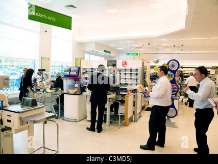 A queue of men at the checkout till, Waitrose supermarket Newmarket Suffolk UK Stock Photo