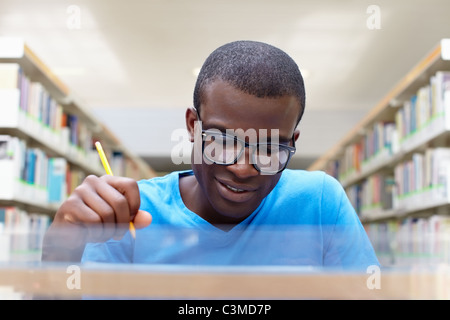 young african american college student reading book in library Stock Photo