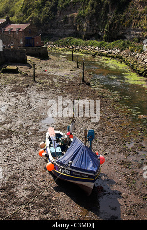 Staithes Beck, coble boat in the estuary of the small fishing village of Staithes, North Yorkshire, England, UK Stock Photo