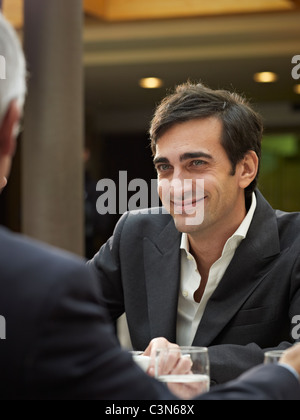 Close up of smiling man in a group meeting Stock Photo