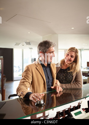 Senior Couple ringing the reception bell in a Hotel Stock Photo