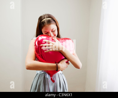 Woman embracing heart shaped balloon