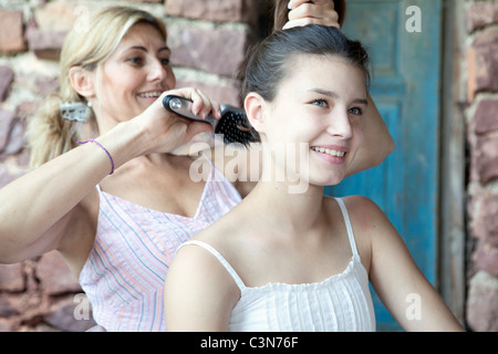 Mother brushing daughter's hair Stock Photo
