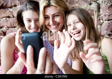 Mother and daughters video call on phone Stock Photo