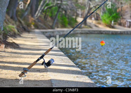 Fishing rod with a floater near the lake. Stock Photo