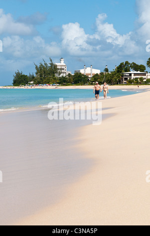 Couple holding hands honeymoon walking on Brighton Beach or Cockspur beach Barbados, Caribbean. Stock Photo