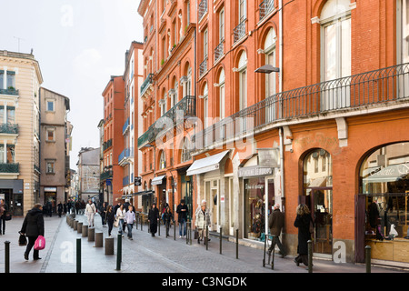 Shops on Place de la Trinite looking down Rue des Filatiers in the city centre, Toulouse, Haute Garonne, Midi Pyrenees, France Stock Photo