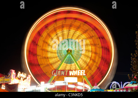 Ferris wheel in motion light streaks with amusement booths Evergreen State Fair Monroe Washington State USA Stock Photo