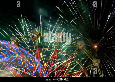 Evergreen State Fair ferris wheel at night with rides and motion with fireworks Snohomish County Monroe Washington State USA Stock Photo