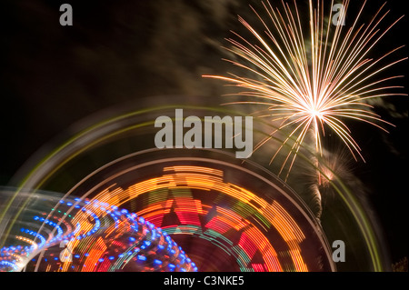 Evergreen State Fair ferris wheel at night with rides and motion with fireworks Snohomish County Monroe Washington State USA Stock Photo