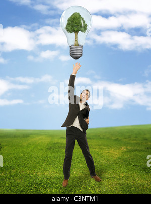 Businessman reaching green energy symbol Stock Photo