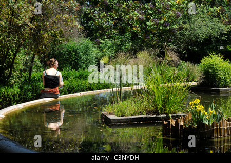 Tourist resting near the pond, Lisbon Botanical Garden, Principe Real, Lisbon, Portugal Stock Photo