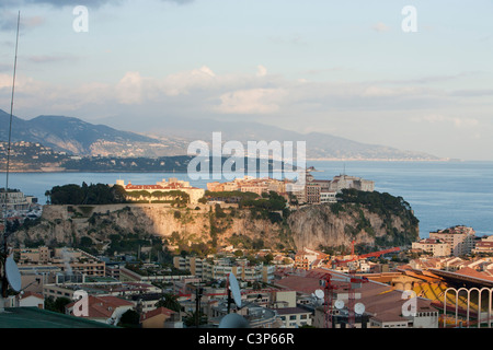 The royal palace and old town of Monaco on le Rocher, the Rock, with the sun illuminating the palace and Italy in the distance