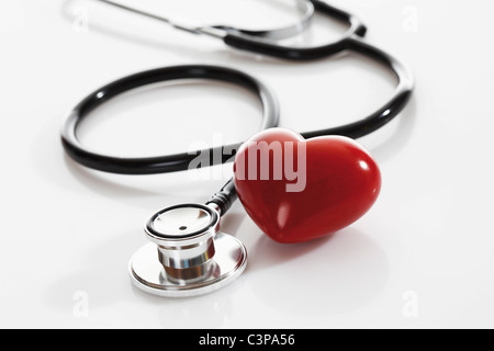 Stethoscope with heart shape object on white background, close up Stethoscope with heart shape object on white background, close up