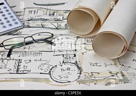 the blueprint of a house with two paper rolls, eyeglasses and a calculator Stock Photo
