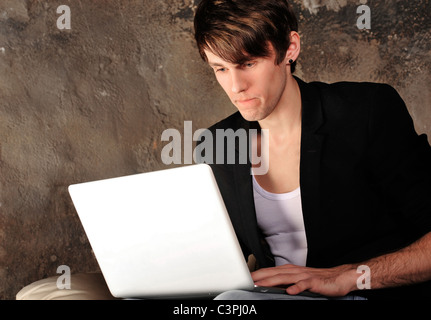 Happy businessman using laptop at his grunge apartment Stock Photo