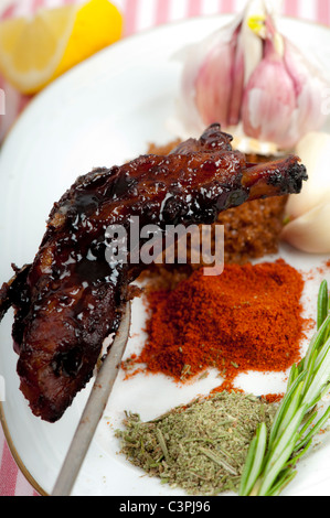 Very sticky spare ribs on a plate with ingredients. Stock Photo