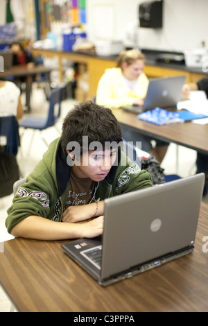 Hispanic boy uses laptop to do research for project in social studies class at middle school in Pflugerville Texas USA Stock Photo