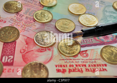 Indian Currency notes of denomination Rs.10 and Rs.5 and coins of denomination Rs.5 with a fountain pen Stock Photo