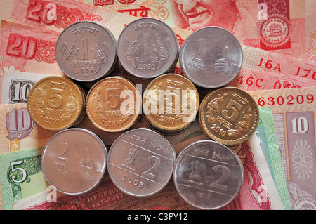 Stack of Indian Currency coins of denomination Re.1,Rs.2 and Rs.5 placed on Indian bank notes of denominations Rs.10,Rs.20,Rs.5 Stock Photo