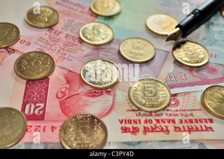 Indian Currency notes of denomination Rs.10 and Rs.5 and coins of denomination Rs.5 with a fountain pen Stock Photo