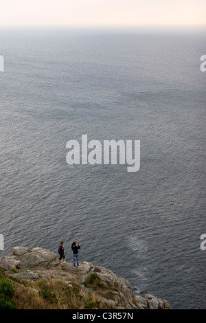 Couple at the edge Finisterre cape. Galicia, Spain Stock Photo