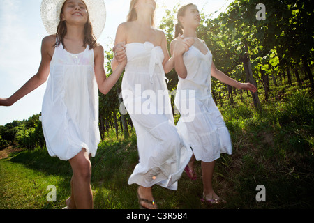 Mother and daughters running in vineyard Stock Photo