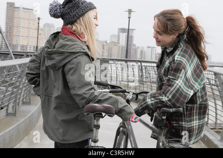 2 young women chatting with push bikes Stock Photo