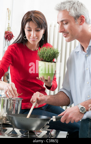 Mid aged couple cooking together Stock Photo
