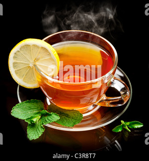 Cup tea with mint and lemon isolated on a black background. Stock Photo