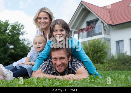 Germany, Munich, Family in front of house, smiling, portrait Stock Photo