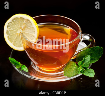 Cup tea with mint and lemon isolated on a black background. Stock Photo