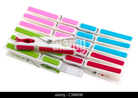 Pile of coloured plastic clothes pegs clipped onto cardboard Stock Photo