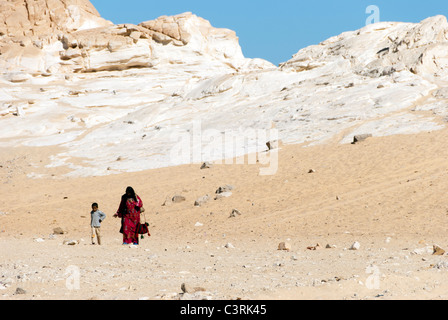 Bedouin woman with child walking in the desert - Sinai Peninsula, Egypt Stock Photo