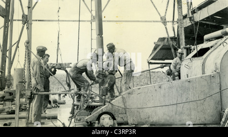 Oil workers drilling during 1938 1930s energy working glass petroleum industry field Stock Photo