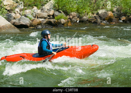 Caucasian girl kayaking in river Stock Photo