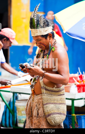 Man dressed as indigenous native using cellphones in Cartagena, Colombia Stock Photo