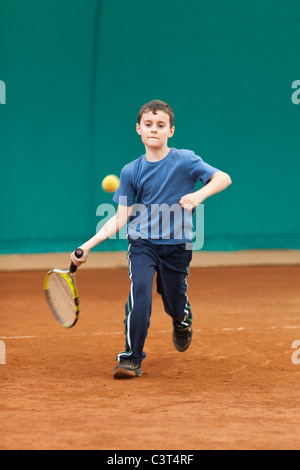 Boy playing tennis on a dross court Stock Photo