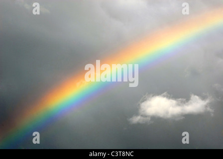 Rainbow on grey cloudy sky. Stock Photo