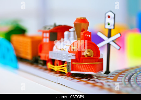 Toy miniature plastic red locomotive on railroad Stock Photo