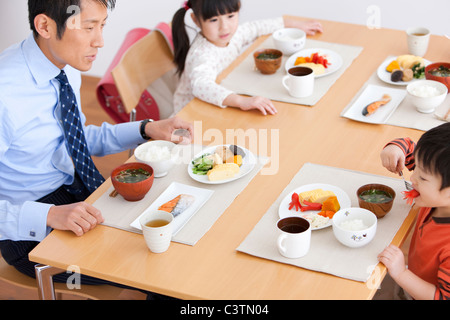 Father and Two Children Having Breakfast Stock Photo