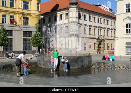 Kids playing by fountain in summer Stock Photo