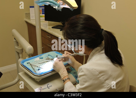 A dentist working with tools to mold a tooth. Stock Photo