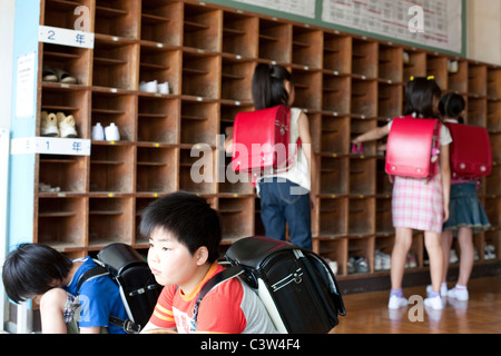 Schoolchildren Putting On Shoes Stock Photo