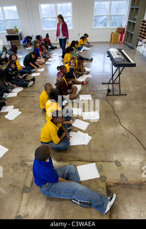 multi-ethnic group of students read sheet music before singing in music class at Rapoport Academy public charter middle school Stock Photo